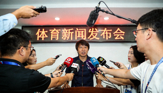 体育新闻发布厅内记者与话筒的现场采访画面